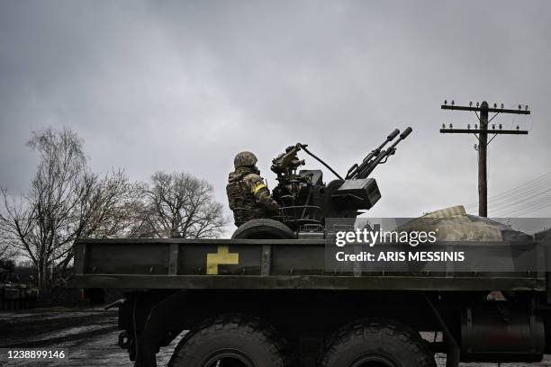 An Ukrainian soldier keeps position sitting on a ZU-23-2 anti-aircraft gun at a frontline, northeast of Kyiv on March 3, 2022. - A Ukrainian...