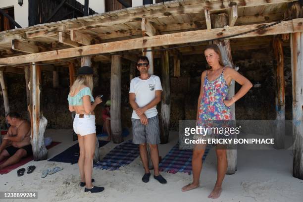 Ukrainian tourists are seen on the beach of a hotel in Zanzibar on March 3, 2022 after they have been left stranded there following the Russian...