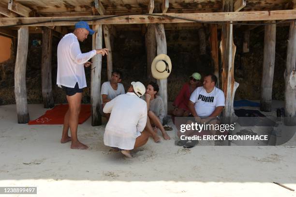 Ukrainian tourists chat on the beach of a hotel in Zanzibar on March 3, 2022 after they have been left stranded there following the Russian invasion...