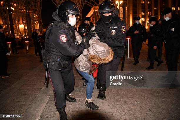 Police officers detain a person during a protest against Russia's invasion of Ukraine in central Moscow on March 3, 2022.