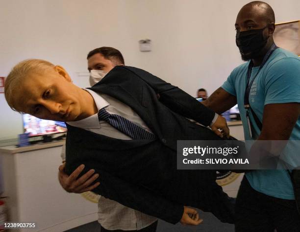 Workers carry the statue of Russian President Vladimir Putin which was removed from the Dreamland wax museum and placed into a warehouse in Gramado,...