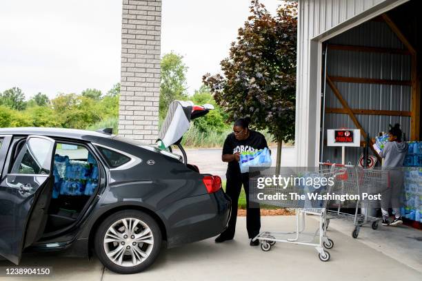 Diana Wiley Washington works with her daughter to load bottled water in their car to be delivered to local seniors as part of an outreach program...