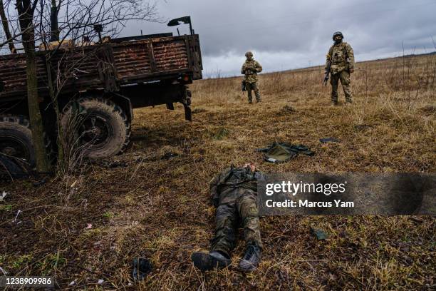 Dead Russian soldier is thrown on the ground, on the side of the road after a Russian vehicle was destroyed Ukrainian forces along the main road near...