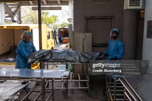 Image depicts death.) Workers wearing personal protective equipment transfer the body of a deceased person at the Fu Shan Public Mortuary in Hong...