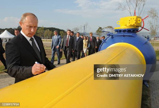 Russia's Prime Minister Vladimir Putin signs an autograph on a natural gas pipeline Sakhalin-Khabarovsk-Vladivostok in the Russian Far East city of...