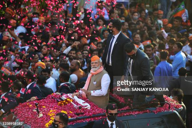India's Prime Minister Narendra Modi gestures during a road show ahead of seventh phase of the Uttar Pradesh state assembly elections in Varanasi on...