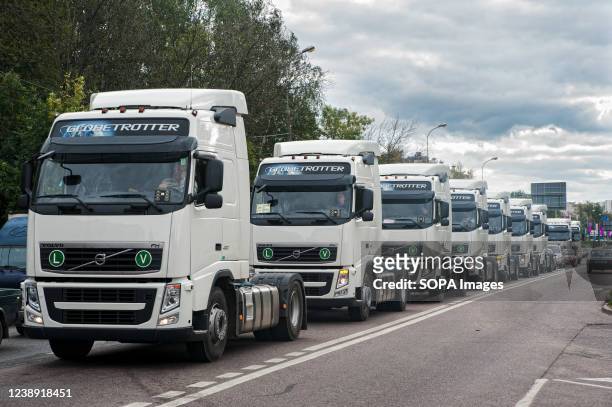 Column of new Volvo truck tractors are traveling along a street in Russia.