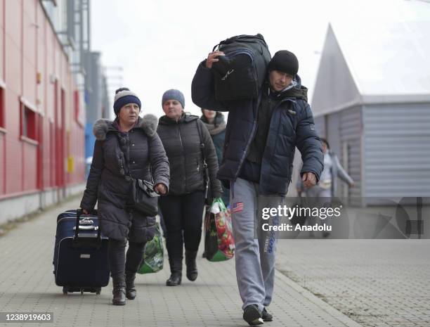 Ukrainian civilians arriving in Poland, wait to go Warsaw by bus at the assembly center near the Korczowa border crossing on the Ukrainian border, in...