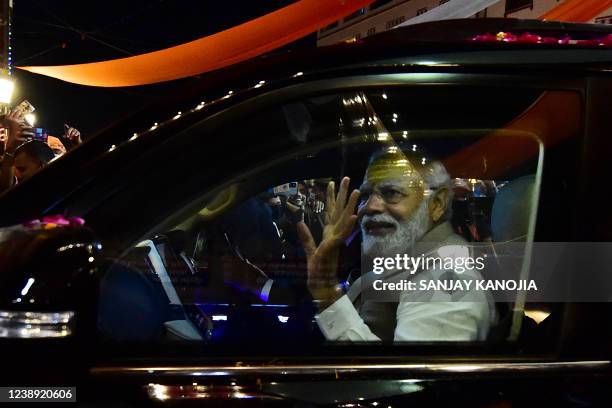 India's Prime Minister Narendra Modi gestures to supporters during a road show ahead of seventh phase of the Uttar Pradesh state assembly elections...