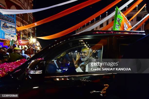 India's Prime Minister Narendra Modi gestures to supporters during a road show ahead of seventh phase of the Uttar Pradesh state assembly elections...