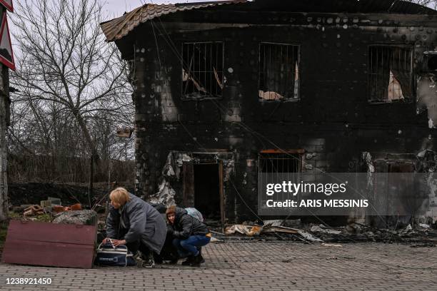 People take cover from shelling in the city of Bucha, west of Kyiv, on March 4, 2022. - The UN Human Rights Council on March 4 overwhelmingly voted...