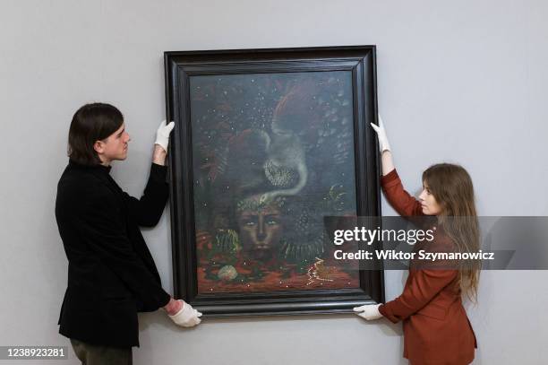 Staff members hold 'Portrait d'Arthur Rimbaud' by Valentine Hugo , estimate: £400,000 - 600,000 during a photo call for The Minds Eye: Surrealist...