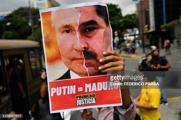 An activist member of opposition party Primero Justicia holds a placard showing the face of Russian President Vladimir Putin and Venezuelan President...