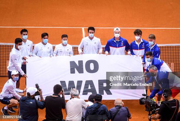 Team Argentina and team Czech Republic hold a flag that reads 'No War' before a match between Sebastian Baez of Argentina and Jiri Lehecka of Czech...