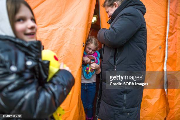 Ukrainian girl looks out from a tent with entertainment for kids in Przemysl. On the 8th day of the Russian invasion in Ukraine thousands of...