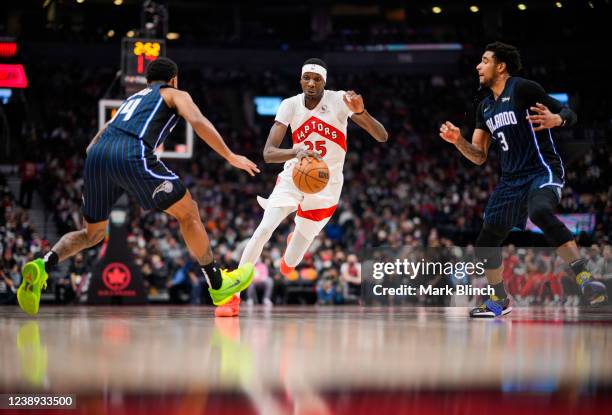 Chris Boucher of the Toronto Raptors drives the ball against Gary Harris and Chuma Okeke of the Orlando Magic during the first half of their...