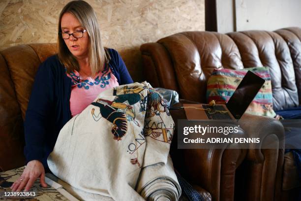 Mia Hansson sits on the couch at home while she works on her embroidery replica of The Bayeux Tapestry in Wisbech, east of England on February 24,...