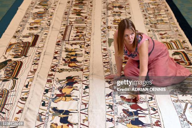 Mia Hansson explains a detail on her embroidery replica of The Bayeux Tapestry at the library in Wisbech, east of England on February 24, 2022. -...