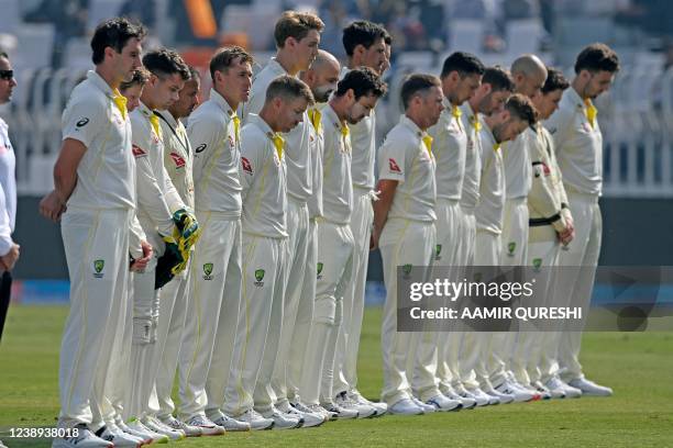 Australia's players observe a minute silence to commemorate former Australian cricketer Shane Warne following his death, before the start of the...