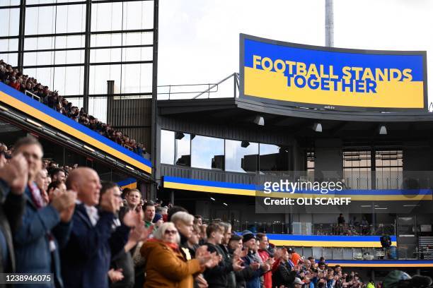 Supporters applaud as a gesture in support of Ukraine, following the country invasion by Russia, prior to the start of the English Premier League...