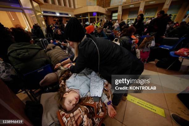 Ukrainian refugees tired from the long journey rest in the railway station of the city Rzeszow Glowny, near the border between Ukraine and Poland....