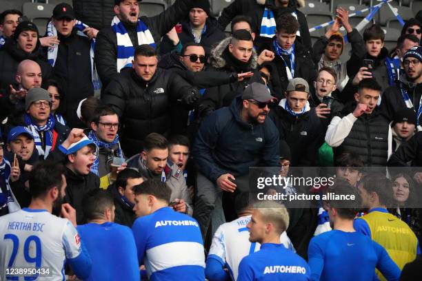 March 2022, Berlin: Soccer: Bundesliga, Hertha BSC - Eintracht Frankfurt, Matchday 25 at the Olympiastadion. Upset fans discuss with Hertha's players...