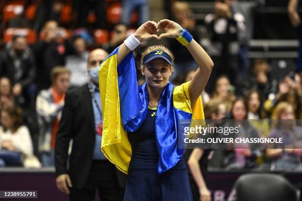 Ukraine's Dayana Yastremska, wrapped in the Ukrainian national flag, reacts at the end of the WTA 6eme Sens Open semi-final tennis match against...