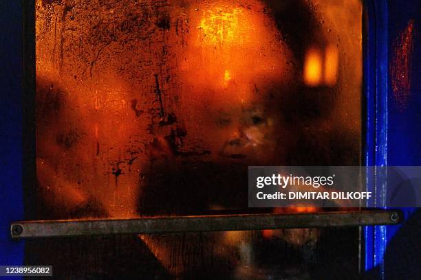 Woman is visible through the condensation on a window of an evacuation train at Kyiv central train station on March 5, 2022. - The UN Human Rights...