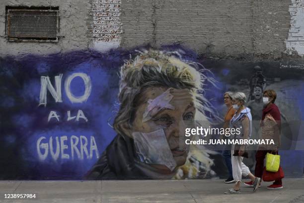 Women walk pass the mural "No to war" by muralist Maximiliano Bagnasco in Buenos Aires on March 5, 2022. - Bagnasco paint this mural against the war...