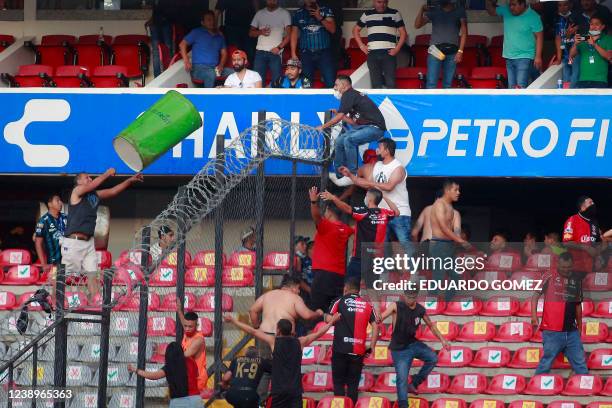 Supporters of Atlas fight with supporters of Queretaro during the Mexican Clausura tournament football match between Queretaro and Atlas at...