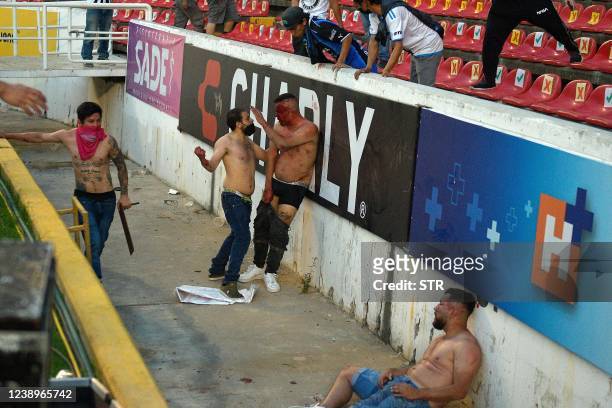 Supporters of Atlas fight with supporters of Queretaro during the Mexican Clausura tournament football match between Queretaro and Atlas at...