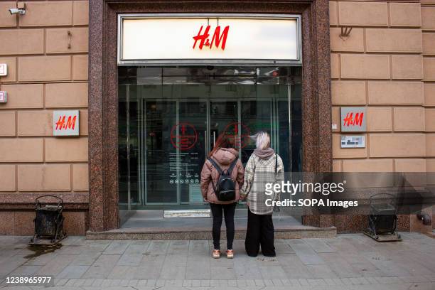 Girls stand in front of the closed doors of the H&M fashion outlet in Moscow. H&M closed its boutiques in Russia in light of the countryís military...