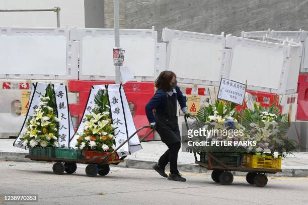 Woman transfers wreaths at the Fu Shan Public Mortuary in Hong Kong on March 6, 2022 as the city is in the throes of its worst-ever Covid-19...
