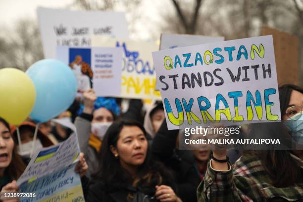 Demonstrators hold placards during a rally in support of Ukraine in Almaty on March 6, 2022.