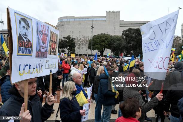 Demonstrator holds a sign depicting Russia's President Vladimir Putin and reading "Stop Putin" during a demonstration in support of Ukraine and to...