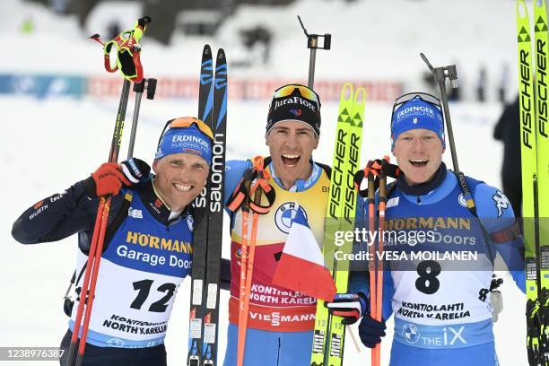 Second placed Erik Lesser of Germany, winner Quentin Fillon Maillet of France and third placed Lukas Hofer of Italy celebrate after the Men's Pursuit...