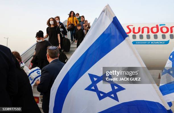 Passengers disembark from an airplane carrying Jewish immigrants fleeing the war in Ukraine, upon arrival in Israel's Ben Gurion Airport in Lod near...