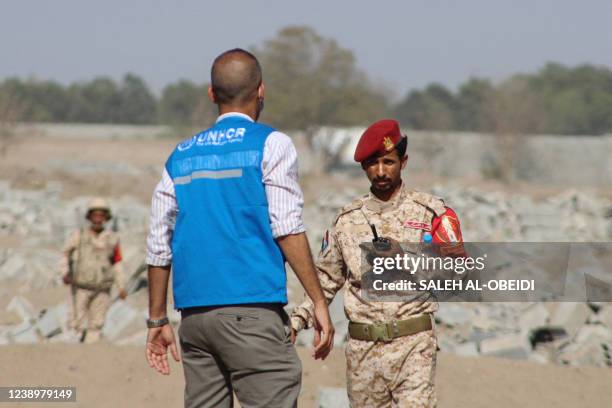 United Nations High Commission for Refugees staff member speaks to a Yemeni security official as UNHCR special envoy Angelina Jolie visits a camp for...