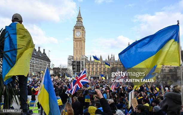 Demonstrators hold placards, Ukrainian and British flags during a protest rally for a Stop the War in Ukraine Global Day of Action, in central...