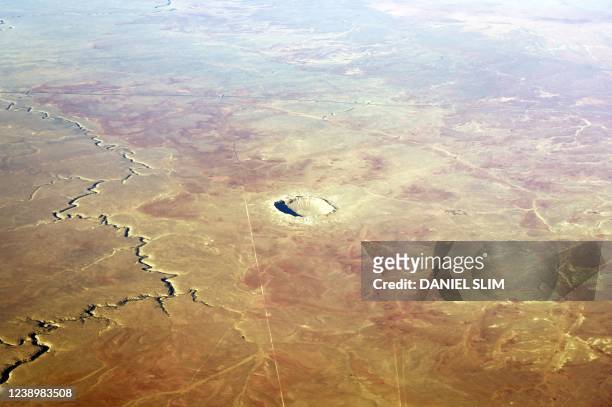 The Meteor Crater near Winslow, Arizona, is seen from a plane February 28, 2022. - The Meteor Crater, sometimes known as the Barringer Crater and...
