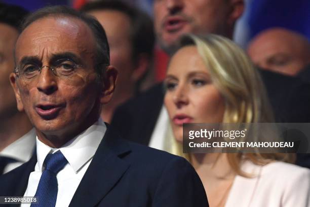 France's far-right party Reconquete! leader and candidate for the 2022 presidential election Eric Zemmour acknowledges the audience flanked by French...