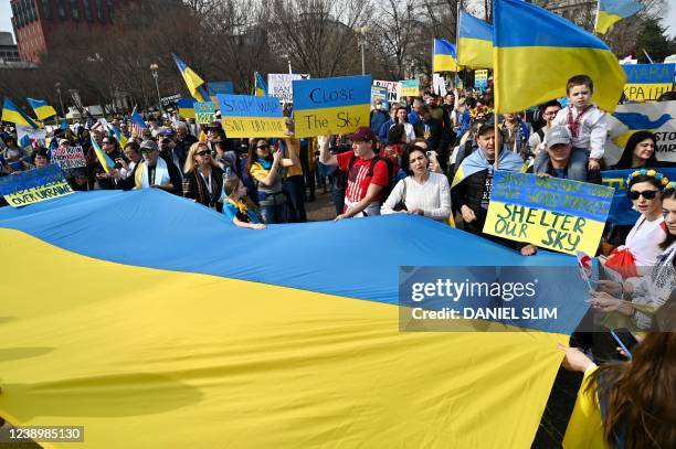 Supporters hold up signs and Ukrainian flags during a rally protesting the Russian invasion of Ukraine at Lafayette Square across the White House in...