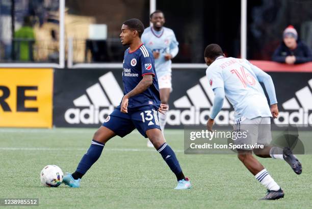 New England Revolution midfielder Lucas Maciel Felix looks to play the ball from FC Dallas forward Tsiki Ntsabeleng during a match between the New...