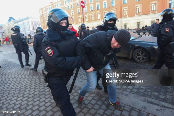 Police Officers detain a protestor during a demonstration against the Russian military operation in Ukraine.