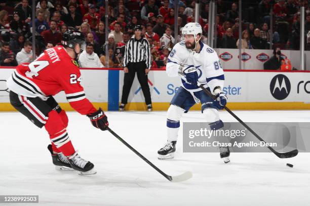 Nikita Kucherov of the Tampa Bay Lightning takes control of the puck in front of Sam Lafferty of the Chicago Blackhawks in the third period at United...