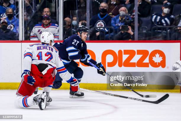 Nikolaj Ehlers of the Winnipeg Jets plays the puck as Patrik Nemeth of the New York Rangers defends during third period action at the Canada Life...