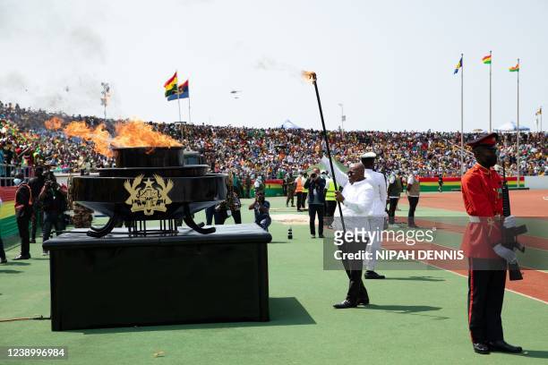 President of Ghana, Nana Akuffo Addo, waves at the crowd after kindling the Eternal Flame of Independence at the celebrations for Ghana 65th...
