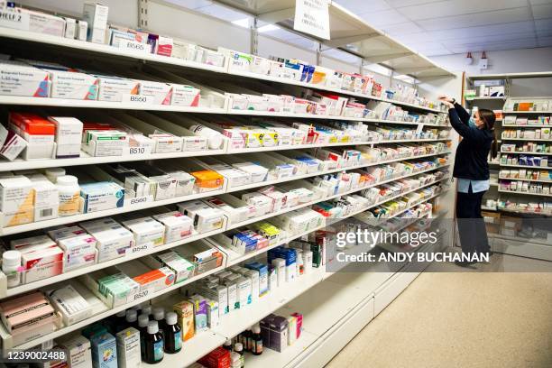 Trainee pharmacy staff member puts in order medications in drawers and shelves at the Monklands University Hospital, in Aidrie, Lanarkshire, on March...