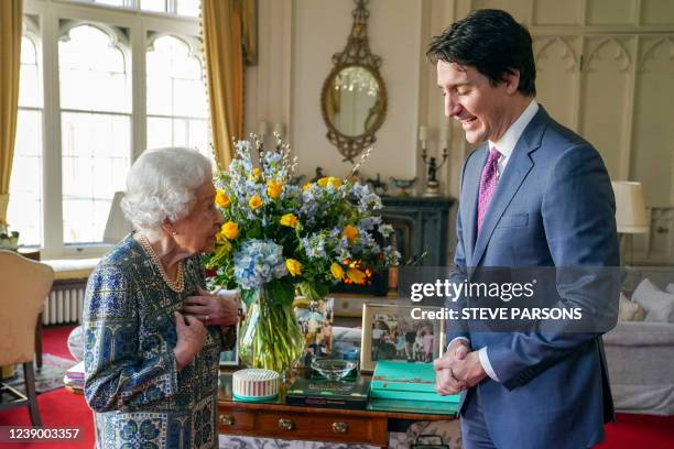 Britain's Queen Elizabeth II speaks with Canadian Prime Minister Justin Trudeau during an audience at the Windsor Castle, Berkshire, on March 7, 2022.