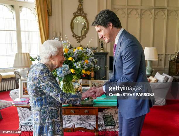 Britain's Queen Elizabeth II shakes hands with Canadian Prime Minister Justin Trudeau as they meet for an audience at the Windsor Castle, Berkshire,...